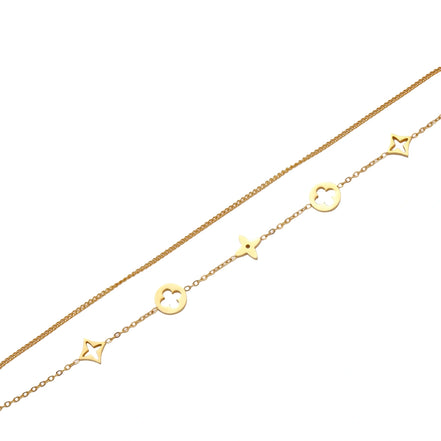 Double-layer gold-plated bracelet with quatrefoil and star charms on cream background, 18K gold finish.